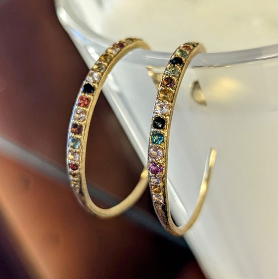 Photo of "Stars" Tourmaline Hoops in a decorative scene, designed by , available at Plumb Gold & Plumb Silver