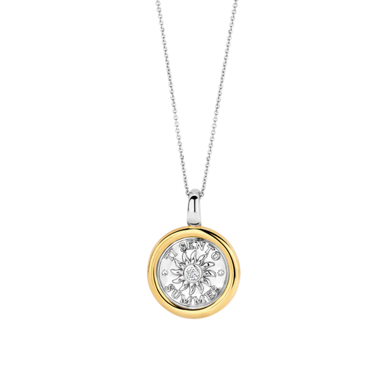 Photo of Summer Sun Coin Pendant in a decorative scene, designed by , available at Plumb Gold & Plumb Silver