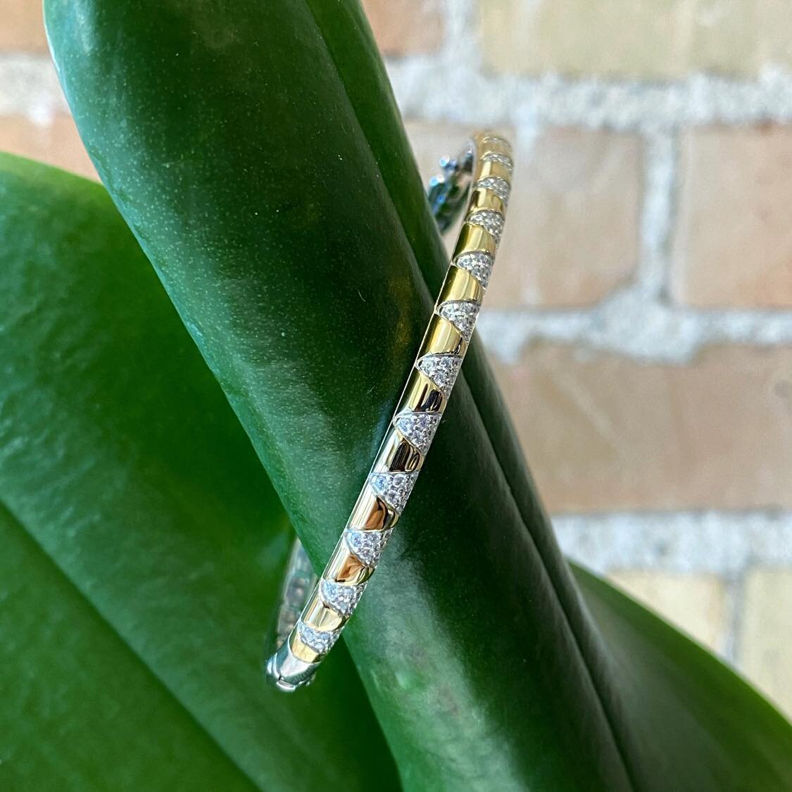 Photo of Sunburst Bangle Bracelet in a decorative scene, designed by , available at Plumb Gold & Plumb Silver