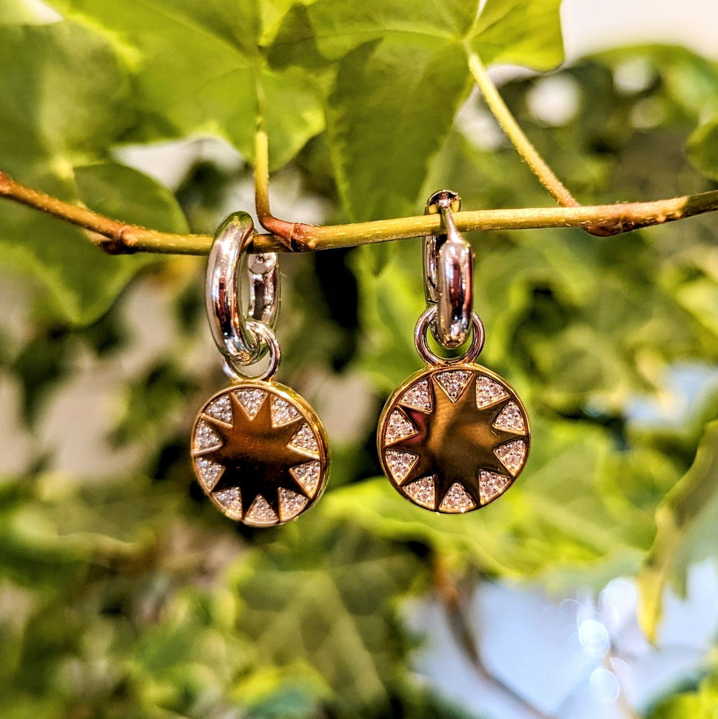 Photo of Sunburst CZ Hoop Charms in a decorative scene, designed by , available at Plumb Gold & Plumb Silver