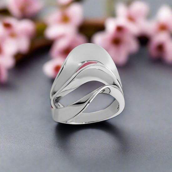 Photo of “Swan” Ring in a decorative scene, designed by , available at Plumb Gold & Plumb Silver