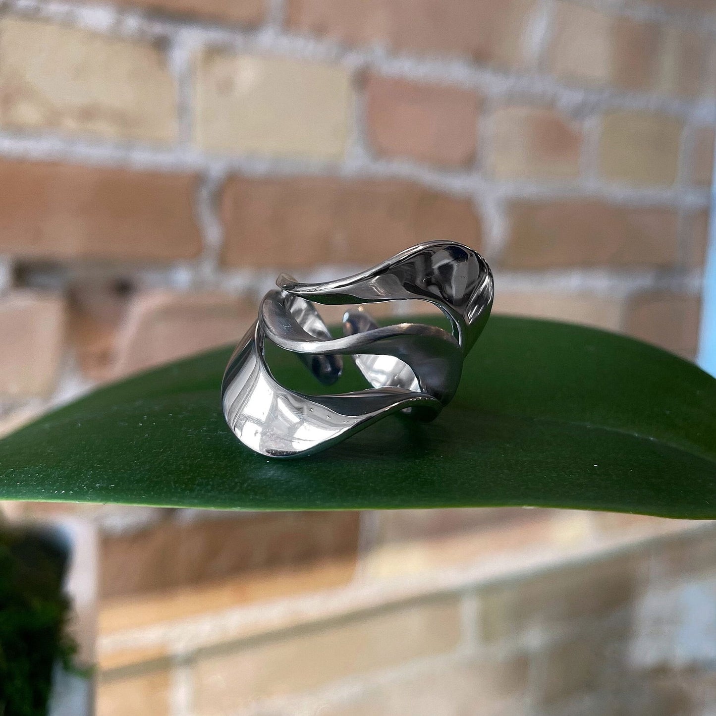 Photo of “Swan” Ring in a decorative scene, designed by , available at Plumb Gold & Plumb Silver