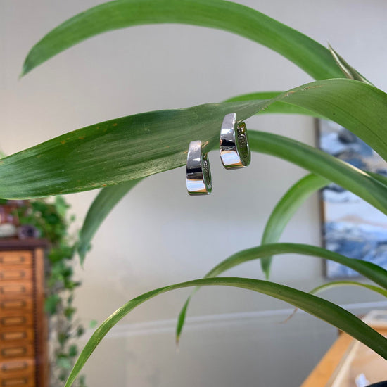 Photo of Tapered Hinged Hoops in a decorative scene, designed by , available at Plumb Gold & Plumb Silver