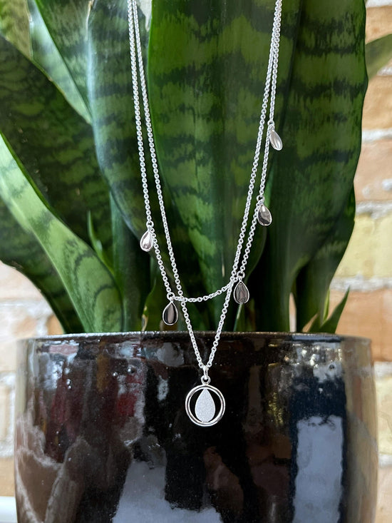 Photo of Teardrop Layered Necklace in a decorative scene, designed by , available at Plumb Gold & Plumb Silver