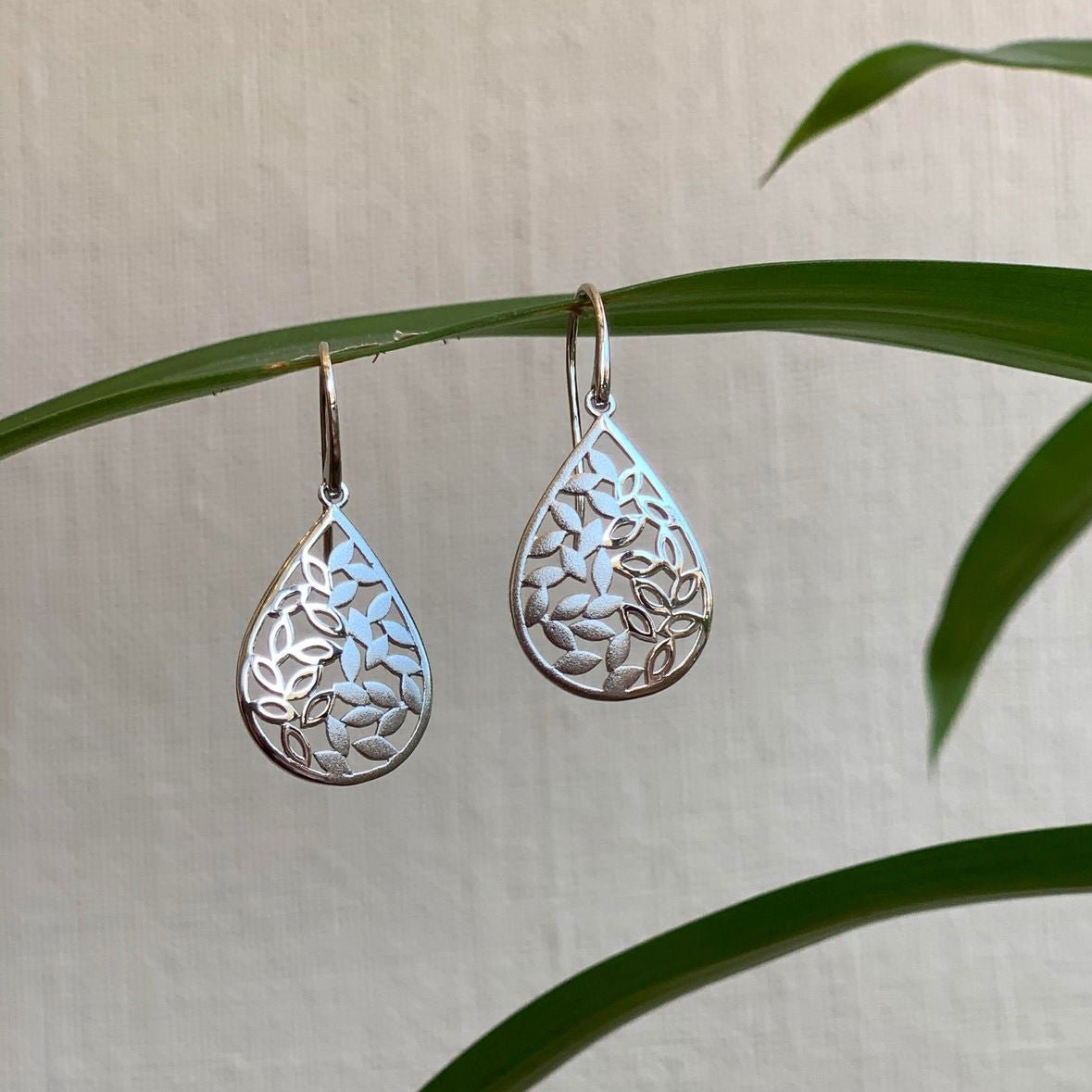 Photo of Teardrop Leaf Dangle in a decorative scene, designed by , available at Plumb Gold & Plumb Silver
