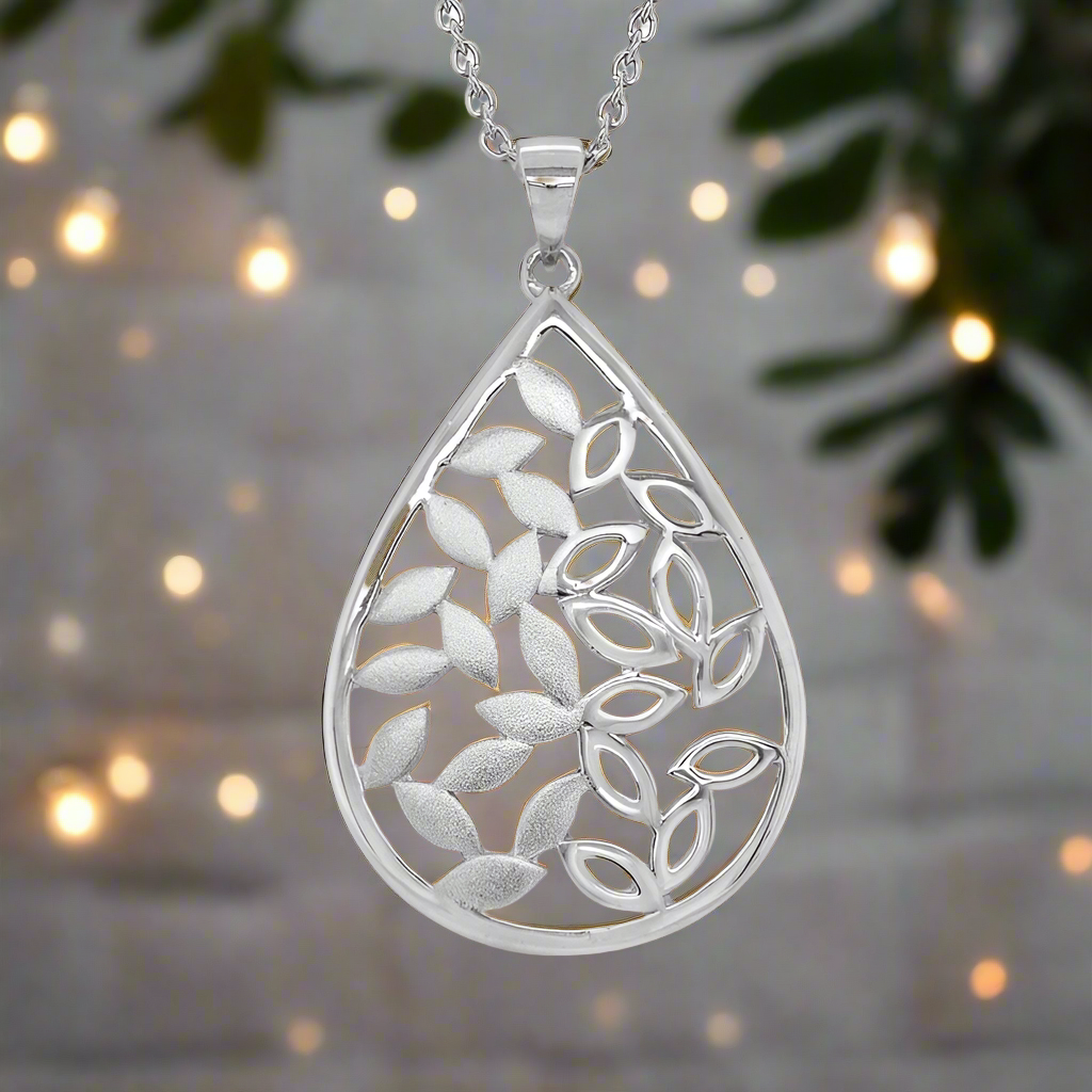 Photo of Teardrop Leaf Necklace in a decorative scene, designed by , available at Plumb Gold & Plumb Silver