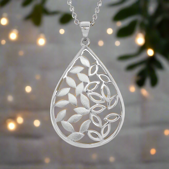 Photo of Teardrop Leaf Necklace in a decorative scene, designed by , available at Plumb Gold & Plumb Silver