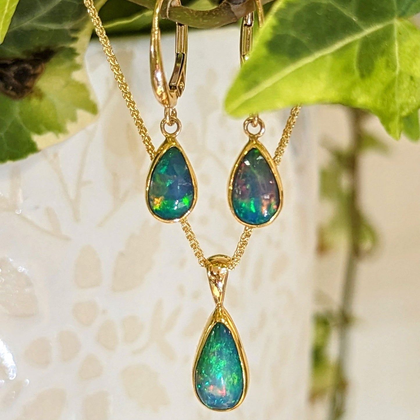 Photo of Teardrop Opal Pendant or Earrings in a decorative scene, designed by , available at Plumb Gold & Plumb Silver