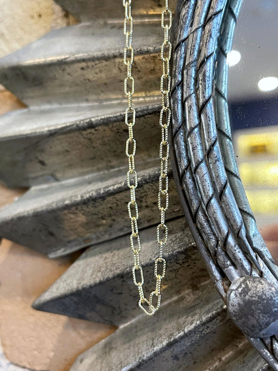 Photo of Textured Paperclip Chain in a decorative scene, designed by , available at Plumb Gold & Plumb Silver