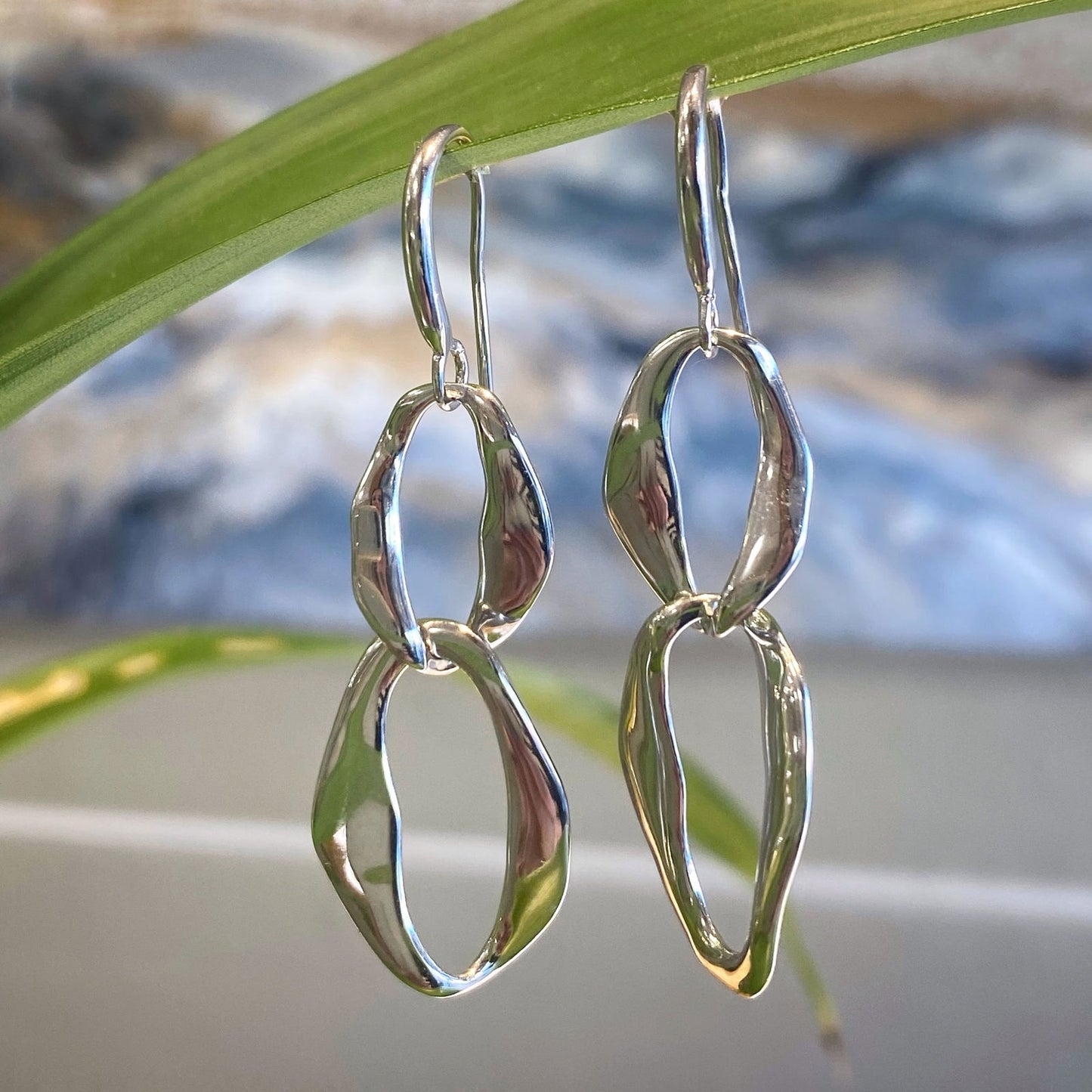 Photo of Together Link Drop Earrings in a decorative scene, designed by -, available at Plumb Gold & Plumb Silver