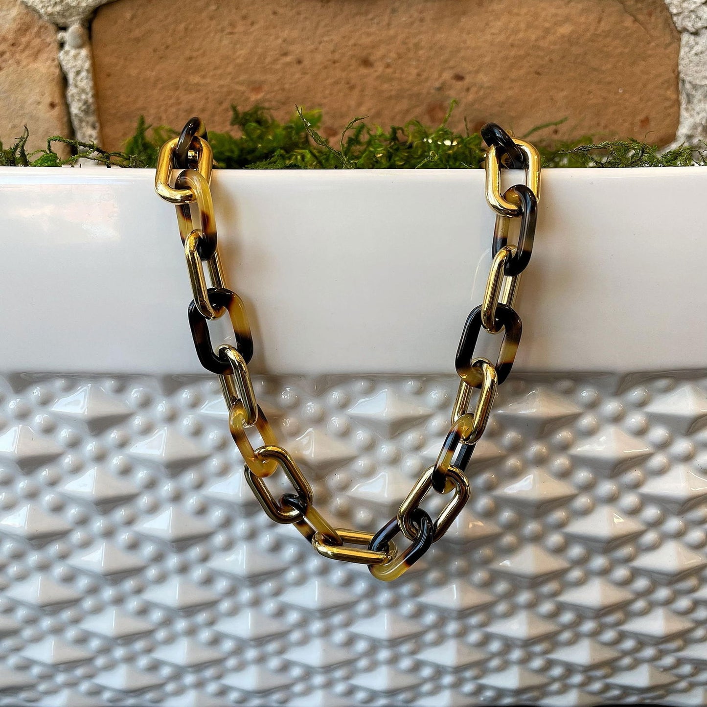 Photo of Tortoise Shell Link Necklace in a decorative scene, designed by , available at Plumb Gold & Plumb Silver