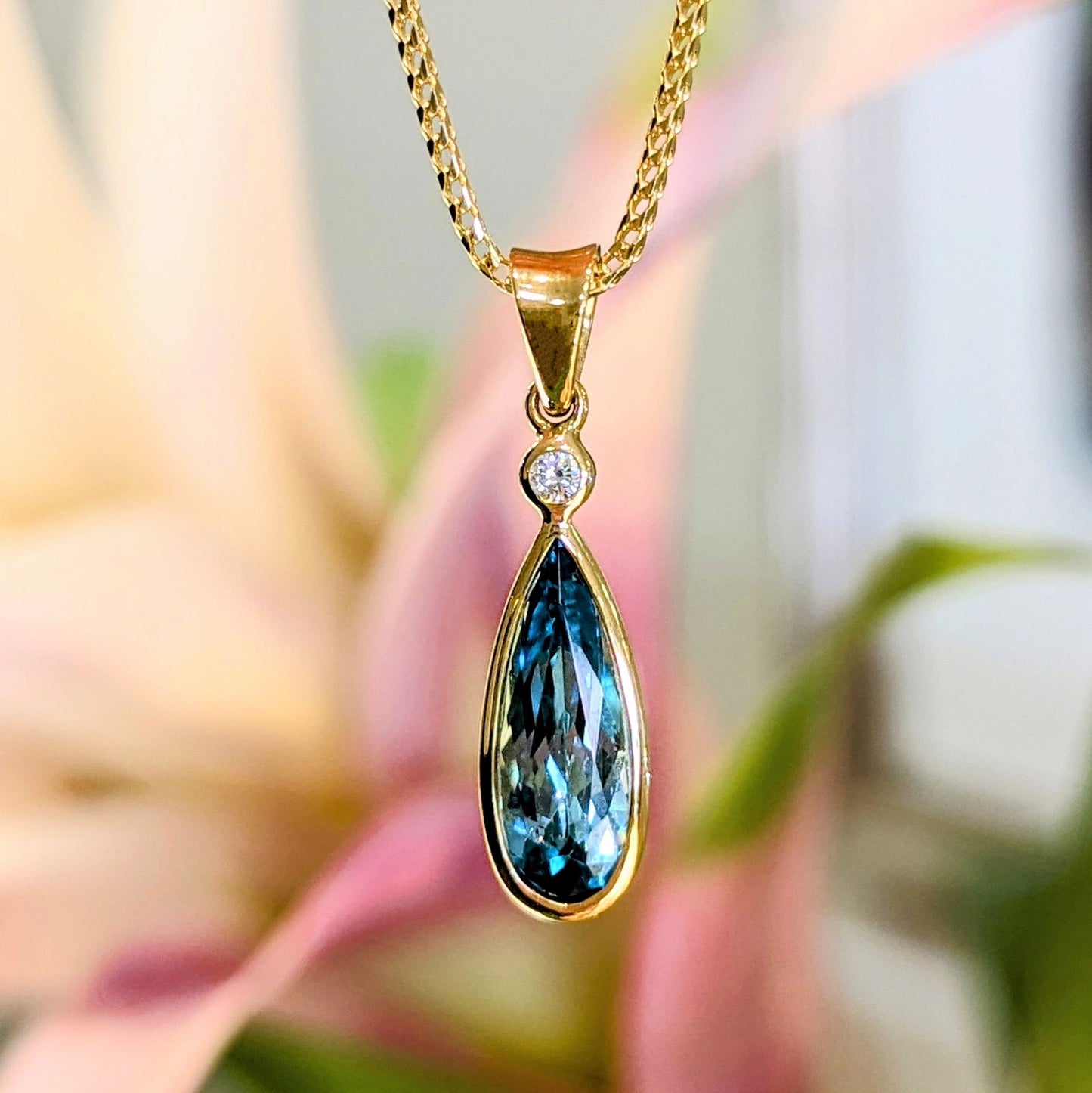 Photo of Tourmaline Drop Pendant in a decorative scene, designed by , available at Plumb Gold & Plumb Silver