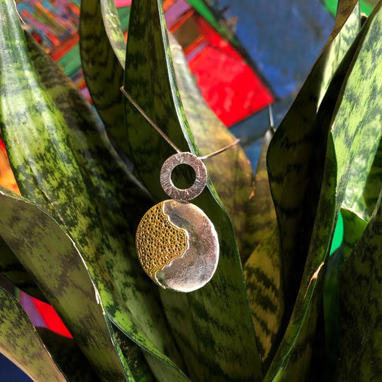 Photo of "Treasure" Pendant in a decorative scene, designed by , available at Plumb Gold & Plumb Silver