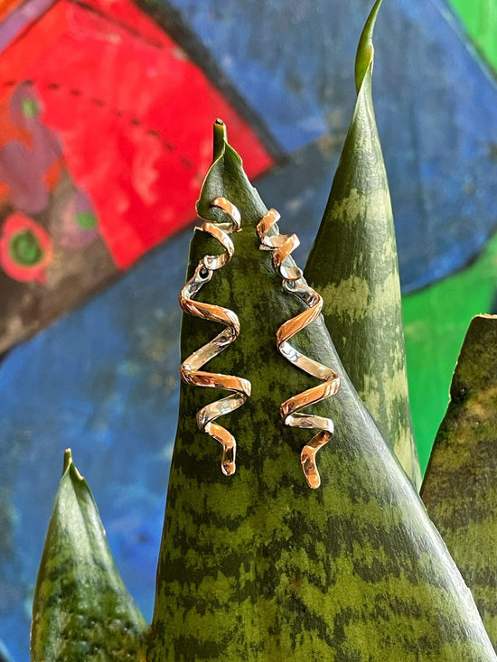 Photo of "Twist" Dangle Earrings in a decorative scene, designed by , available at Plumb Gold & Plumb Silver