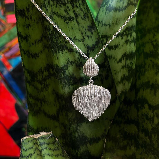 Photo of "Wild Rodio" Pendant in a decorative scene, designed by , available at Plumb Gold & Plumb Silver