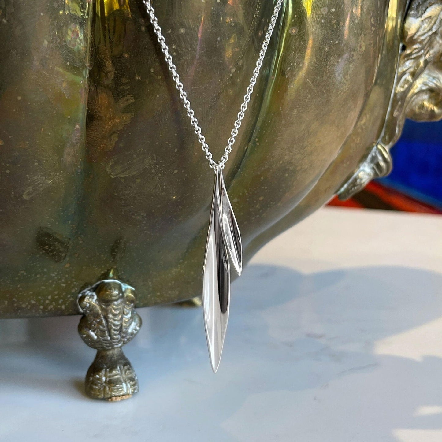 Photo of "Willow" Necklace in a decorative scene, designed by , available at Plumb Gold & Plumb Silver