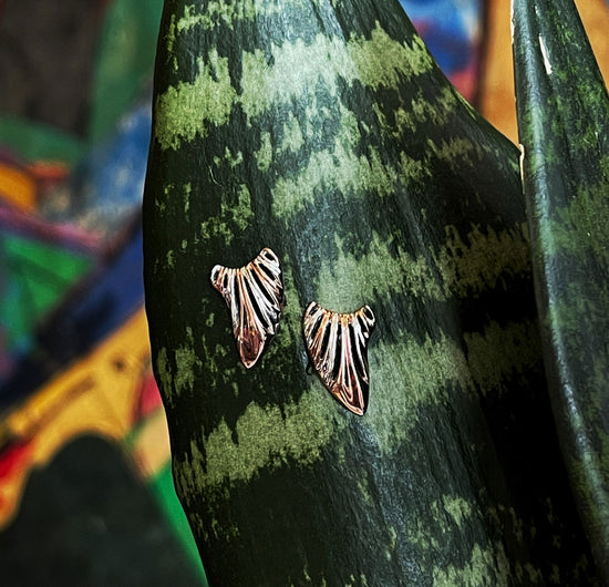 Photo of "Wing" Earrings in a decorative scene, designed by , available at Plumb Gold & Plumb Silver