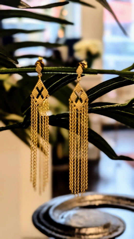 Photo of "X" 18K plated Fringe Earrings in a decorative scene, designed by , available at Plumb Gold & Plumb Silver