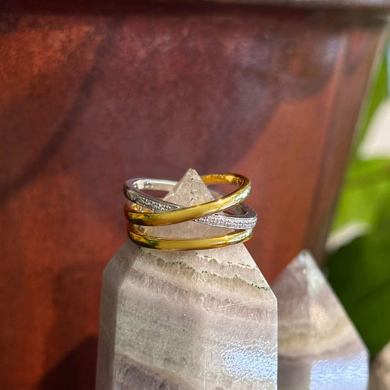 Photo of "X" Ring in a decorative scene, designed by , available at Plumb Gold & Plumb Silver