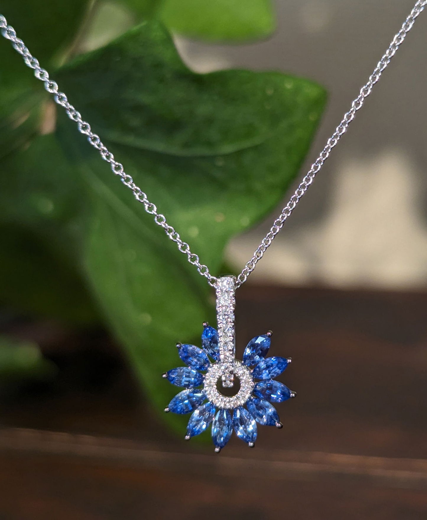 Photo of Zeghani Sapphire and Diamond "Burst" Necklace in a decorative scene, designed by , available at Plumb Gold & Plumb Silver