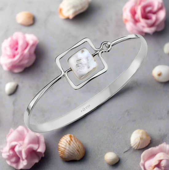 Photo of "Zenith" Bangle in a decorative scene, designed by , available at Plumb Gold & Plumb Silver