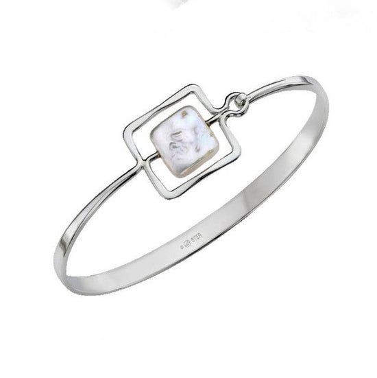 Photo of "Zenith" Bangle in a decorative scene, designed by , available at Plumb Gold & Plumb Silver