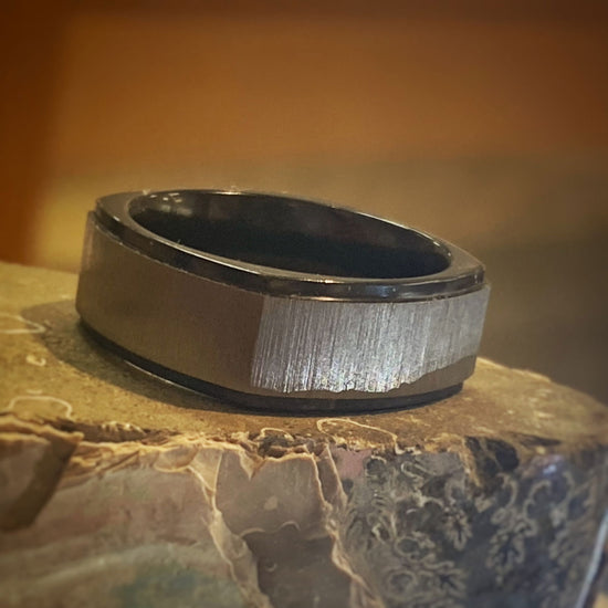 Photo of Zirconium Cross Satin Silver Square Band in a decorative scene, designed by , available at Plumb Gold & Plumb Silver