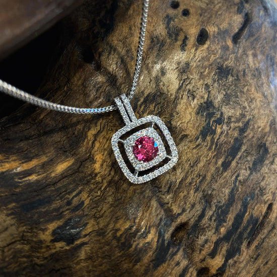Photo of Zoma Color Double Diamond Halo and Pink Spinel Pendant in a decorative scene, designed by , available at Plumb Gold & Plumb Silver
