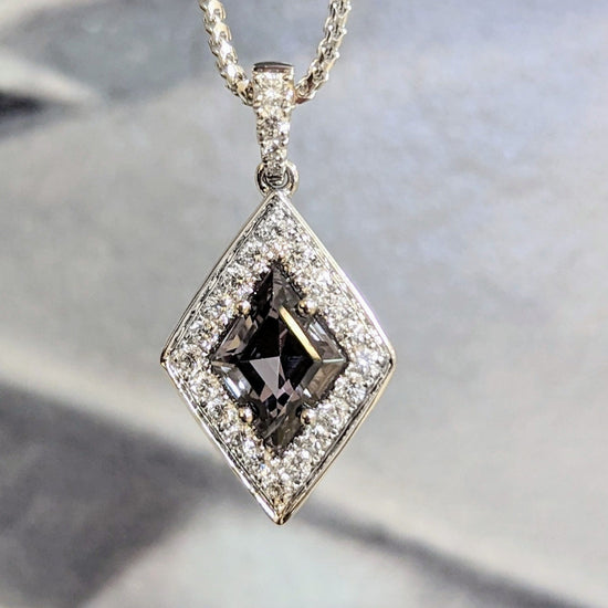 Photo of Zoma Color Grey Spinel Pendant in a decorative scene, designed by , available at Plumb Gold & Plumb Silver
