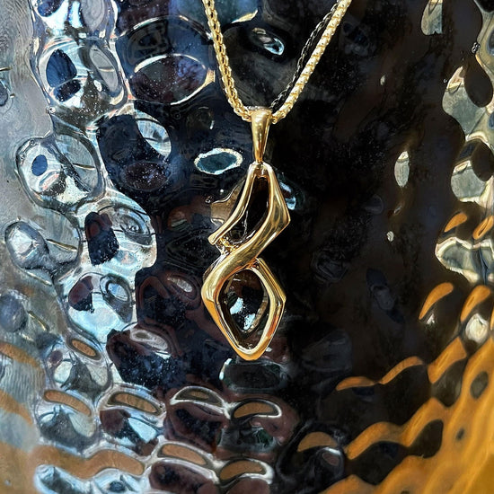 Photo of nfinity Pendant in a decorative scene, designed by , available at Plumb Gold & Plumb Silver