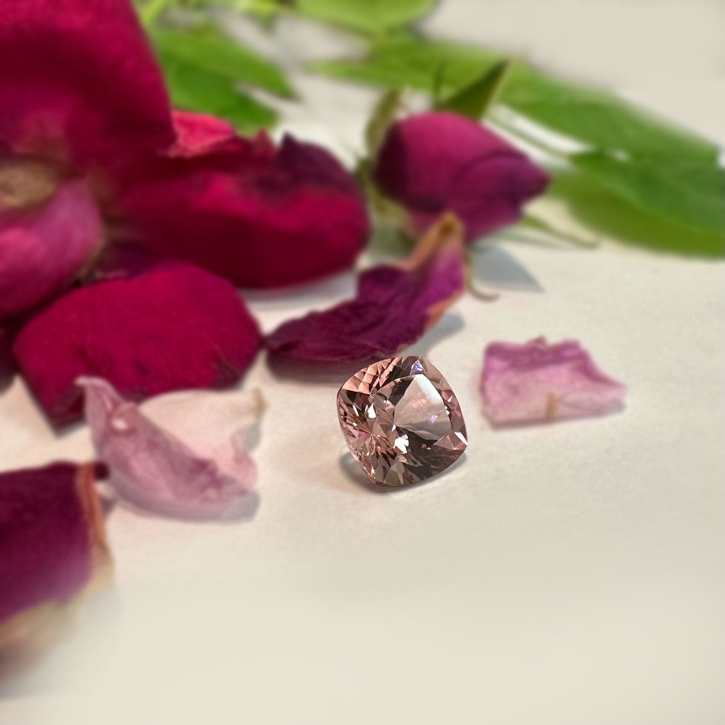 light Pink morganite on a bed of pink petals and leaves