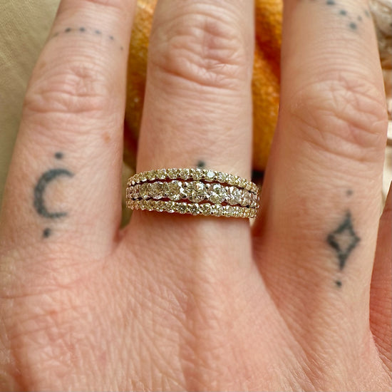 triple diamond and gold band on a finger