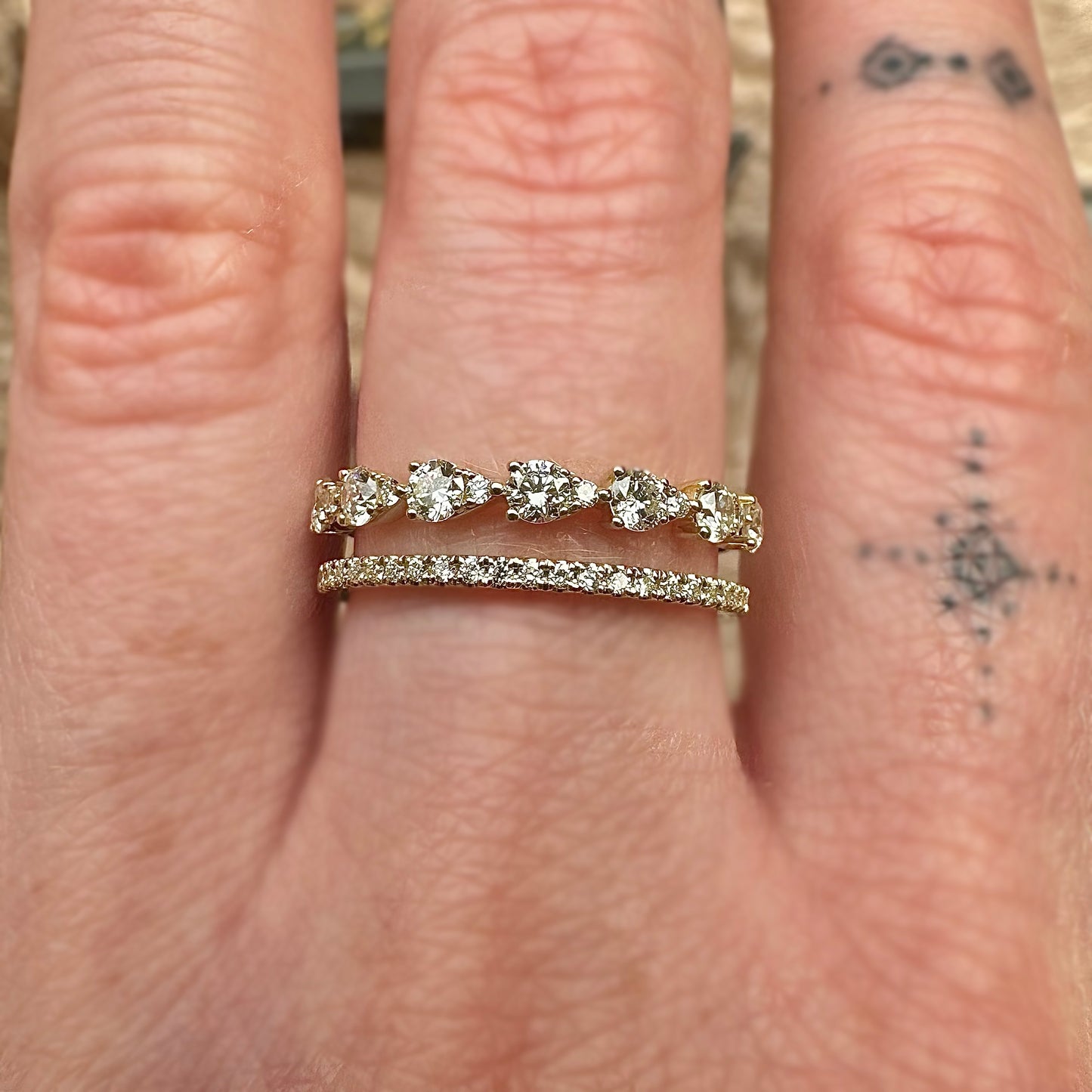 gold and diamond double banded ring on middle finger 