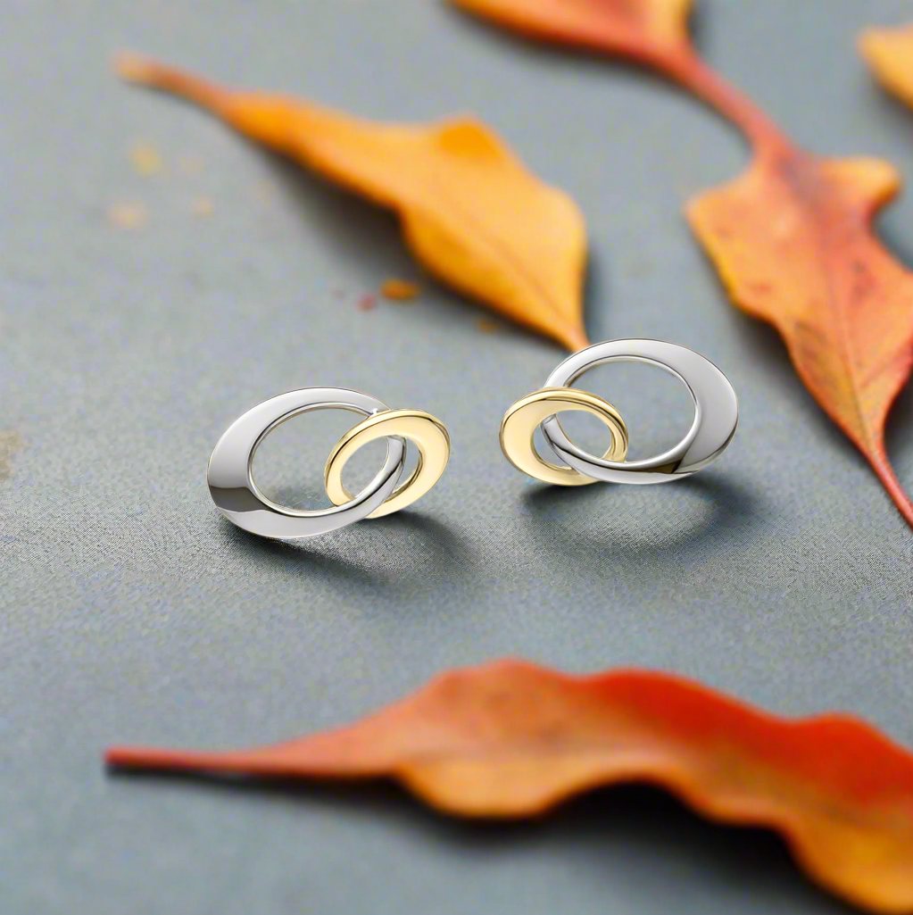 Stud earrings and a decorative scene with fall leaves, available at plumb silver jewelry store